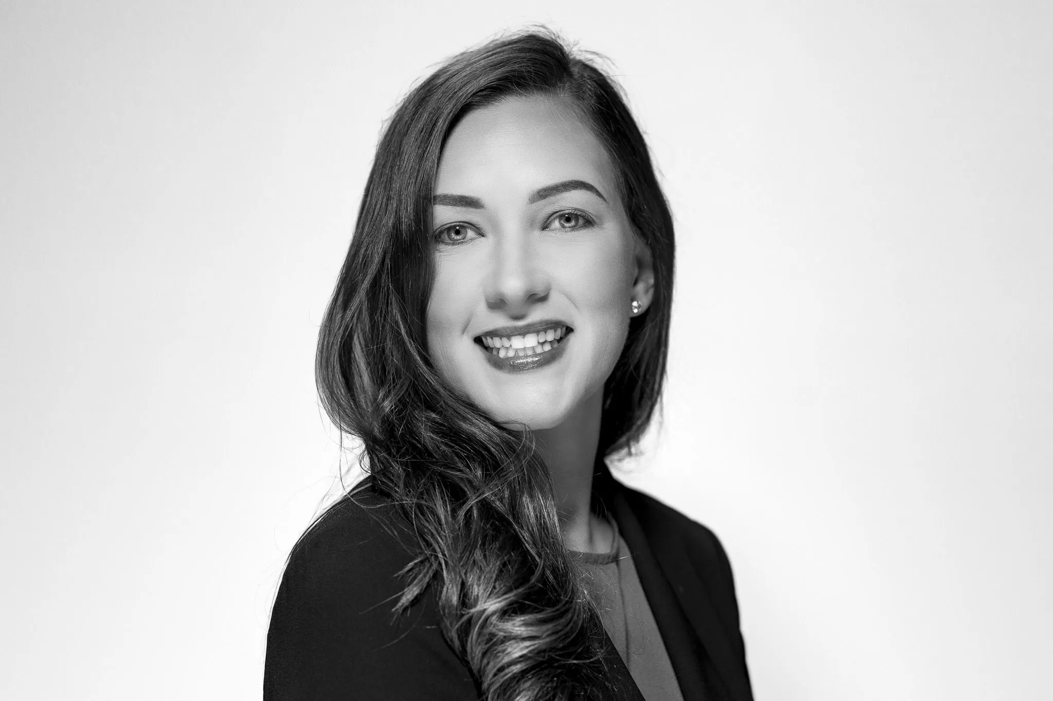 Black and white professional headshot of a woman in a blazer against a white background